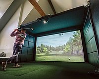 A man plays with a golf simulator configurator